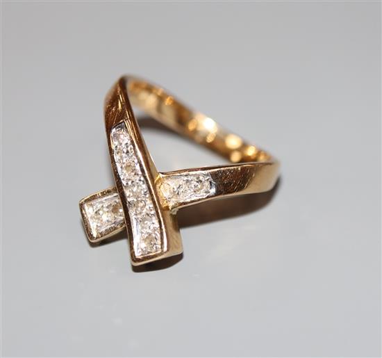 A modern 585 yellow metal and diamond set X ring, size H, gross 4.3 grams.